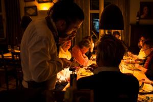 Un uomo in piedi a un tavolo in un ristorante di Mettner Hof a Metten