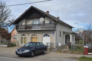 a black car parked in front of a house at Rooms Mila in Rezovac