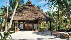 a small hut with a thatched roof on a beach at Kilwa Beach Lodge in Kilwa Masoko