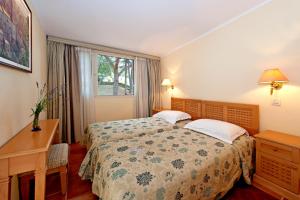 a bedroom with two beds and a desk and a window at Apartments Bellevue Plava Laguna in Poreč