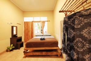 a bedroom with a bed and a window at Omah Konco Yogyakarta in Yogyakarta