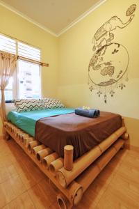 a bed made out of logs with a sign on the wall at Omah Konco Yogyakarta in Yogyakarta