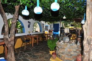 a restaurant with trees and lights and tables and chairs at Pension Titika in Katapola
