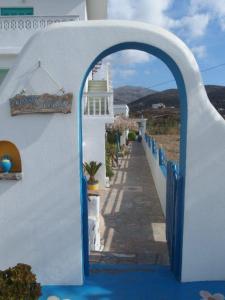 an archway in a white building with a blue door at Pension Titika in Katapola