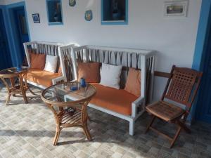 a living room with a couch and a table and chairs at Pension Titika in Katapola