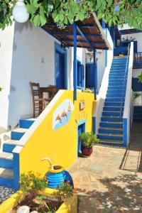 a yellow and blue building with stairs and a stair case at Pension Titika in Katapola