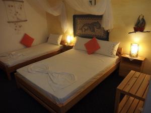 two twin beds in a room with two lamps at Pension Titika in Katapola +27 photos