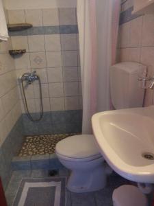 a bathroom with a toilet and a sink at Pension Titika in Katapola