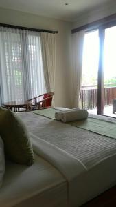 a bedroom with two beds and a large window at ThreeWin Homestay in Ubud