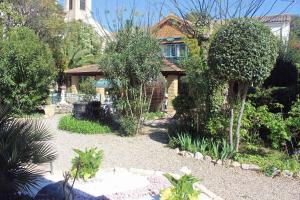 a house with a garden with trees and bushes at Hotel restaurant MARTINEZ in Balaruc-les-Bains