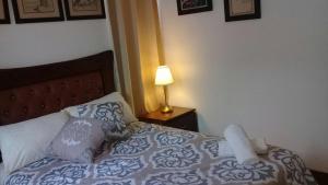 Schlafzimmer mit einem Bett und einer Lampe auf einem Tisch in der Unterkunft Tavalero Rooms in Santo Domingo