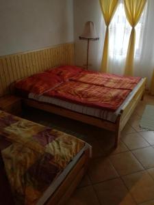 a bedroom with two beds and a window at Guliba Vendégház in Bogács