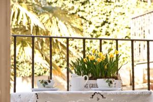 a table with two cups and flowers on a balcony at Casa Azzurra in Menaggio