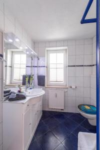 Baño blanco con lavabo y aseo en Villa Mona Lisa - Ferienzimmer 8, en Göhren