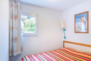 a bedroom with a bed and a window at Residence Le Pedrou - maeva Home in Font Romeu Odeillo Via