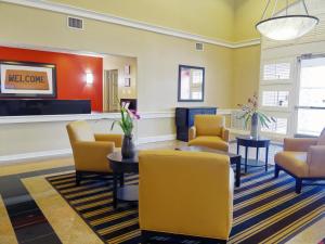 uma sala de espera num hospital com cadeiras e mesas amarelas em LoneStar Suites em Webster