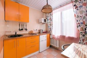 a small kitchen with orange cabinets and a window at Apartamenty Svetlica Krylova 69a in Novosibirsk