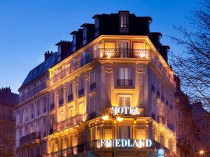 パリにあるHotel Le Friedlandの夜間にライトアップされたホテルの看板がある建物