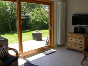 sala de estar con puerta corredera de cristal en Bungalow-M, en Westerland