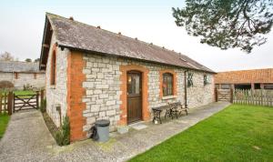 a small brick building with a picnic table in a yard at The Stables in South Barrow