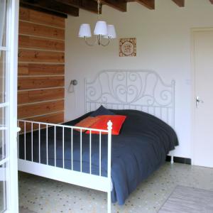 - une chambre avec un lit blanc et un oreiller rouge dans l'établissement Ranch Bignaou, à Amou