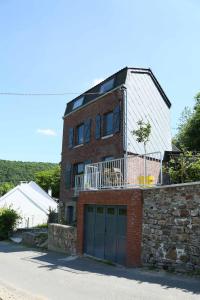 a brick house with a garage in front of it at La petite maison in Aywaille