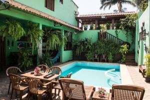 a patio with a table and chairs next to a pool at Águas do Pantanal Inn Pousada in Miranda