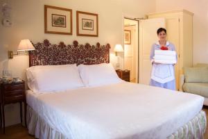 a woman standing in a hotel room with a large bed at Hotel Garden in Siena