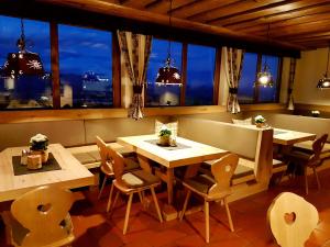 ein Esszimmer mit Tischen, Stühlen und Fenstern in der Unterkunft Hotel Baumgartnerhof in Altfinkenstein