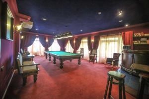 a living room with a pool table and chairs at Sea Club Hotel in Divnomorskoye