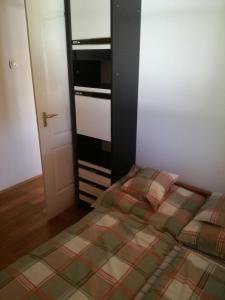 a small bedroom with a bed and an open door at Guliba Vendégház in Bogács