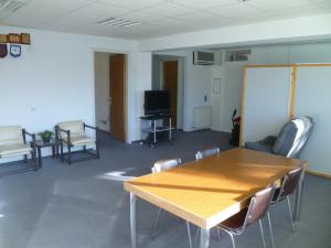 Datacom Guest House في نيقوسيا: غرفة مع طاولة وكراسي وتلفزيون