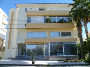 un bâtiment avec des fenêtres et des palmiers en face de celui-ci dans l'établissement Datacom Guest House, à Nicosie