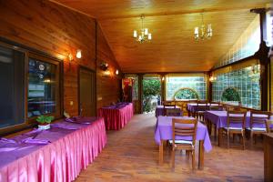 a dining room with tables and purple tablecloths at Bahçe Villa in Cıralı