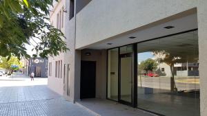 un edificio con puertas de cristal en un lateral de una calle en La Pedrera en Villa María