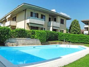 een groot blauw zwembad voor een huis bij Welcome Traveller LA PERLA APARTMENTS in Garda