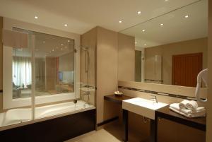 a bathroom with a tub, sink and mirror at Klas Hotel in Istanbul