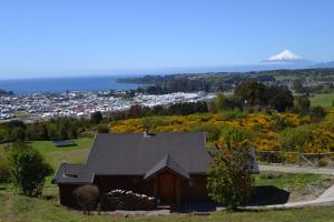 una casa en una colina con vistas a la ciudad en Cabañas Krause Lodge, en Puerto Varas