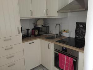 a kitchen with white cabinets and a stove top oven at Münster City Apartment in Münster