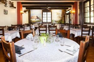 a dining room with a table with white table cloth at Logis Hotel Restaurant Le Flamant Rose camargue in Albaron