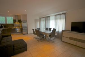 a kitchen and living room with a table and chairs at la maison de bonneval in Jaujac