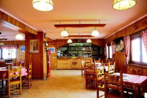 a restaurant with wooden walls and tables and chairs at Hotel Folgore in Passo Stelvio