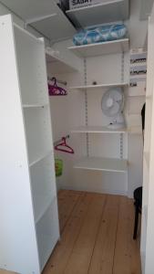 um closet com armários brancos e piso de madeira em Appartement Duplex em Bretenoux