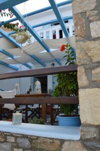 a patio with a table and chairs and blue ceilings at Stella's traditional house. in Alonnisos