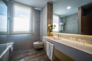 a bathroom with a sink and a toilet and a window at Hotel Venta Baños in Cañada Hermosa