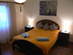 a bedroom with a bed with two towels on it at Casa Uldina in Bombarral