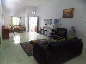 a living room with a couch and a tv at Amelia 2 Guest House Syariah in Medan