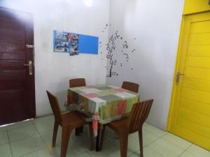 una mesa de comedor con sillas y una caja en ella en Amelia 2 Guest House Syariah, en Medan