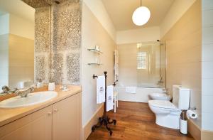 a bathroom with a sink and a toilet and a tub at Casa da Portela de Sampriz in Ponte da Barca +56 photos