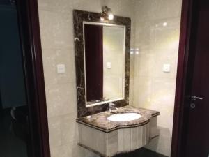 a bathroom with a sink and a mirror at Mkani Apartment in Al Khobar